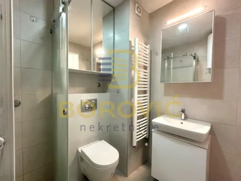 Moderno opremljeno kupatilo sa tuš kabinom, umivaonikom i ugradnim toaletom. - image 6