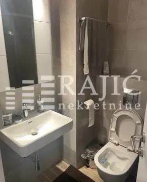 Modernly equipped bathroom with a washbasin and toilet. - image 7