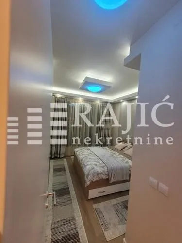 View from the hallway into a furnished bedroom with a double bed.