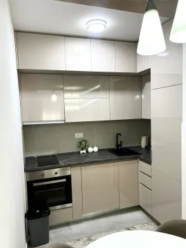 Manja kuhinja sa bež elementima i tamnom radnom pločom. - image 4