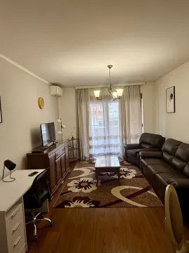 A furnished living room featuring a brown leather sofa, a TV stand, and a study desk. - image 3