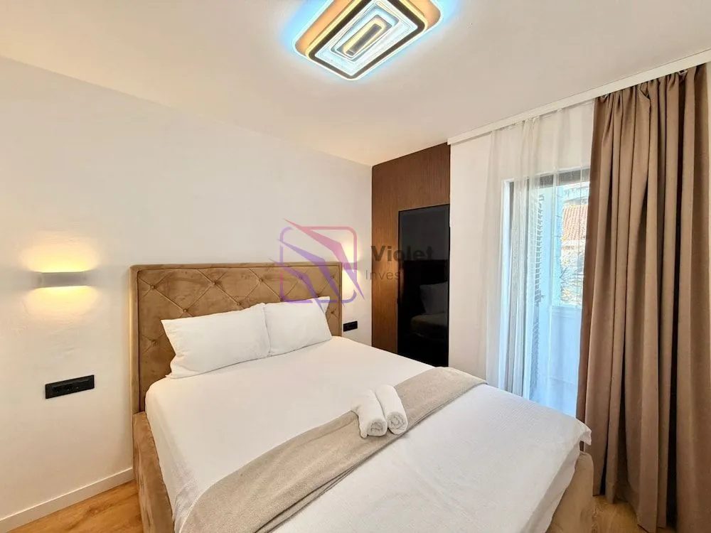 Furnished bedroom with a double bed and a window.