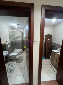 Pogled na dva kupatila sa tuš kabinom i sanitarijama kroz otvorena vrata. - image 15