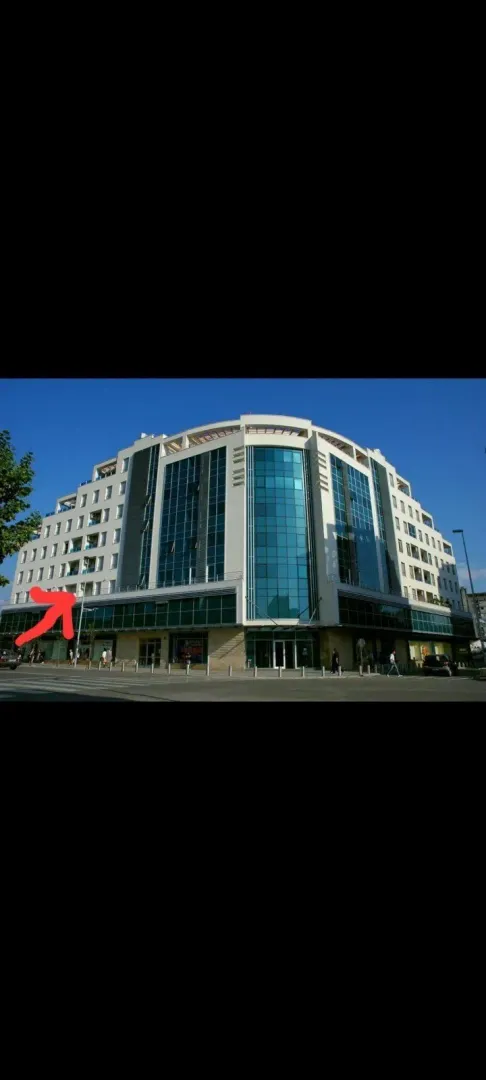 Exterior view of a modern residential and commercial building with a glass facade.