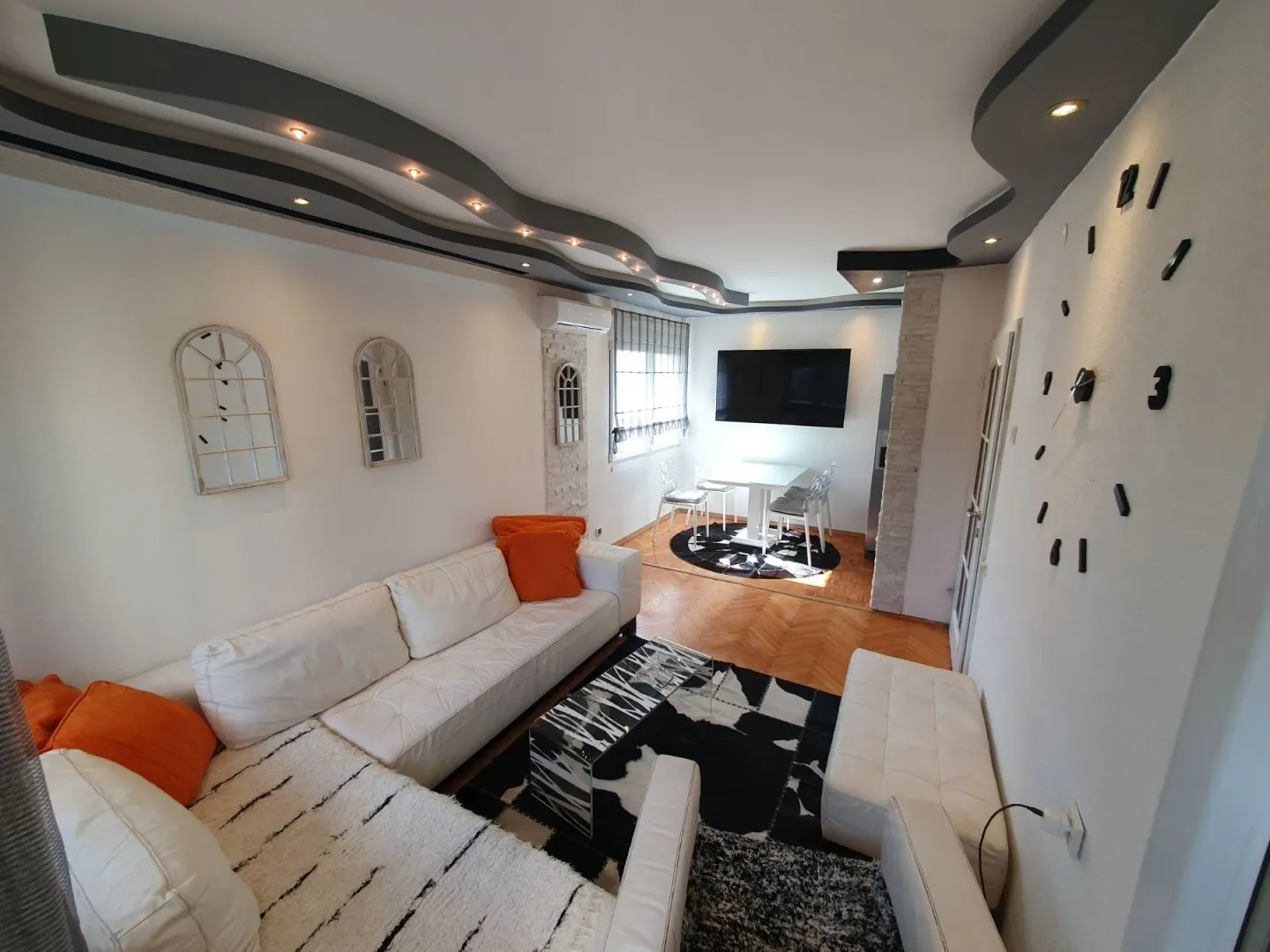 Spacious living room with seating furniture and decorative dropped ceiling.