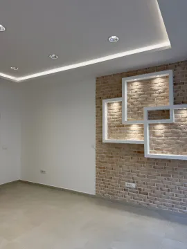 Empty living room with a decorative brick wall and recessed lighting. - image 5
