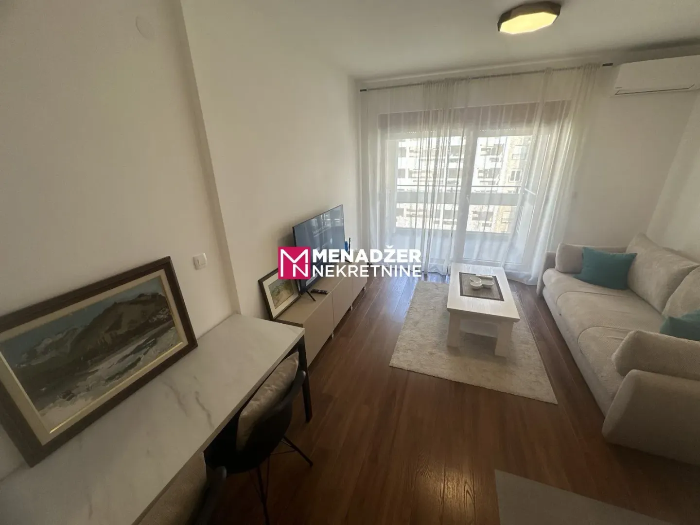 Bright and tidy living room with a sofa and TV unit.