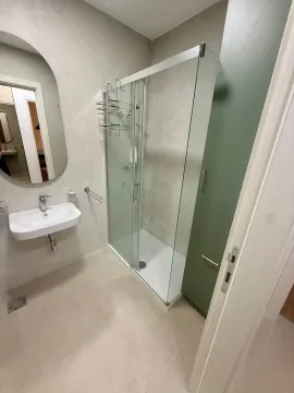 Modern bathroom with a shower cabin, washbasin, and mirror. - image 8