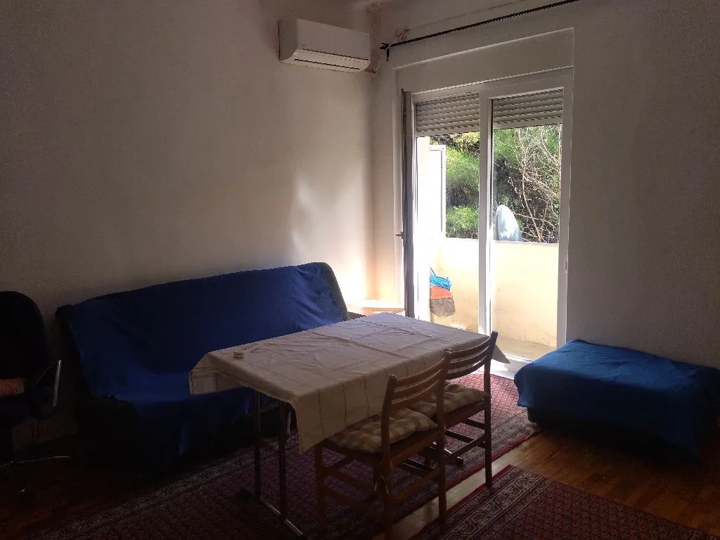 Living room with sofa, dining table, and access to the terrace.