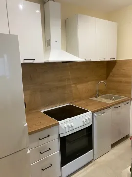 Kitchen with white cabinetry, wooden countertops and built-in appliances. - image 13