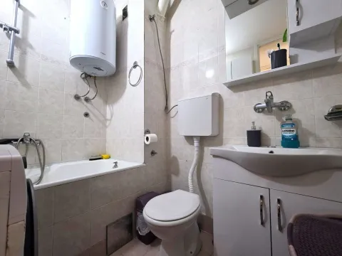 Manje kupatilo obloženo keramičkim pločicama sa kadom, toaletom i umivaonikom. - image 12