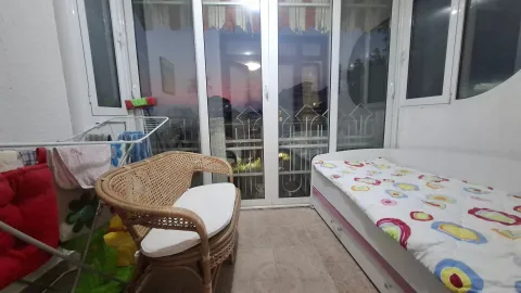 Manja spavaća soba sa krevetom, pletenom klupom i izlazom na terasu. - image 3