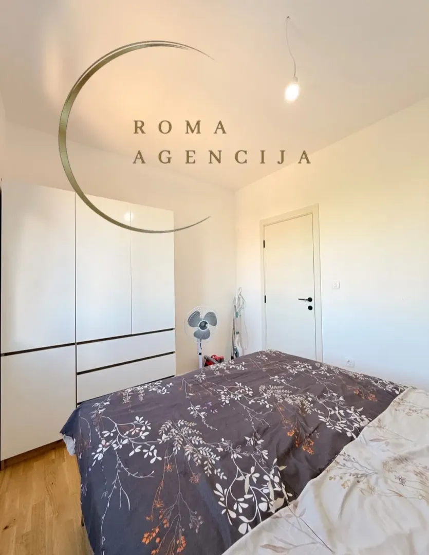 Bright and furnished bedroom with a double bed and a fitted wardrobe.