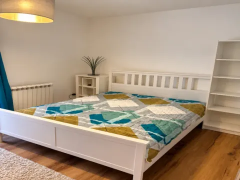 Bedroom with a double bed, white shelving units and wooden flooring. - image 5