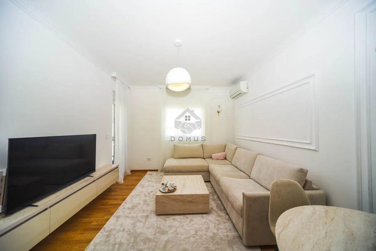 Living room with a corner sofa, television, and dining table.