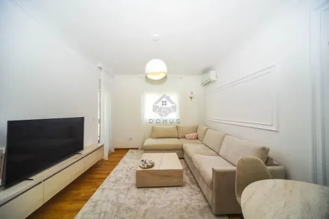 Living room with a corner sofa, television, and dining table. - image 2