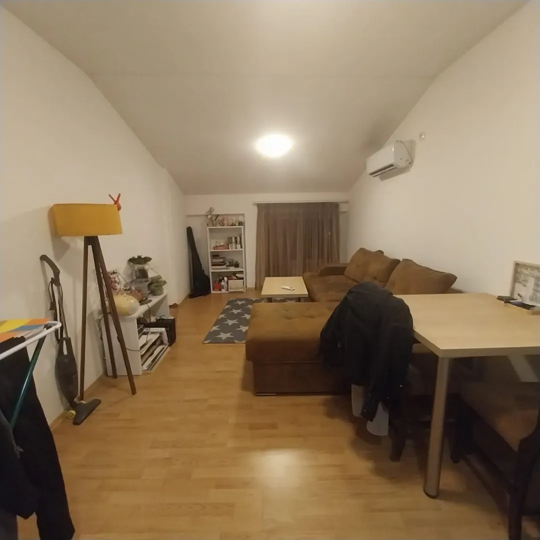 Prostrana dnevna soba sa ugaonom garniturom, trpezarijskim stolom i parketom.