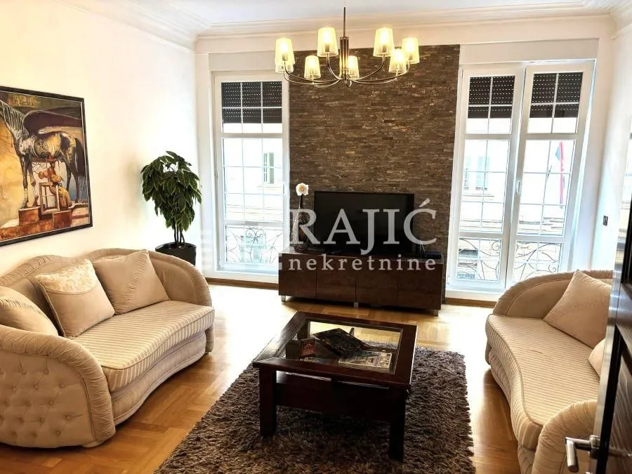 Furnished living room with a sofa set and a decorative accent wall.
