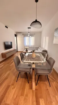 Bright living room with a dining table and a corner sofa. - image 2