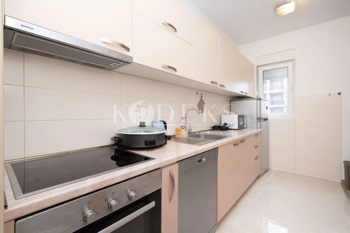 Kitchen equipped with kitchen units, built-in oven, hob, and refrigerator.