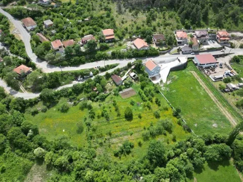 Pogled iz vazduha na prostrani zeleni plac i okolne kuće. - image 3