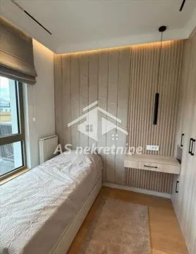 Small bedroom with a bed, built-in wardrobes, and wall panels. - image 12