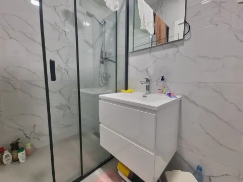 Modern bathroom with a shower cabin and a washbasin. - image 10