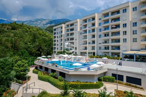 Exterior of an apartment building with a swimming pool and landscaped courtyard. - image 5