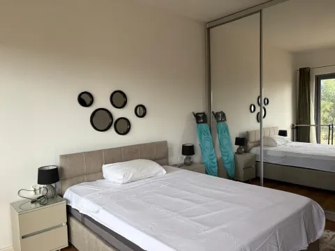 Furnished bedroom with a double bed, mirrored wardrobe, and nightstands. - image 2