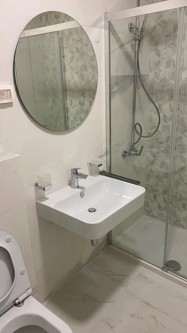 Modern bathroom with a shower cabin and a sink.