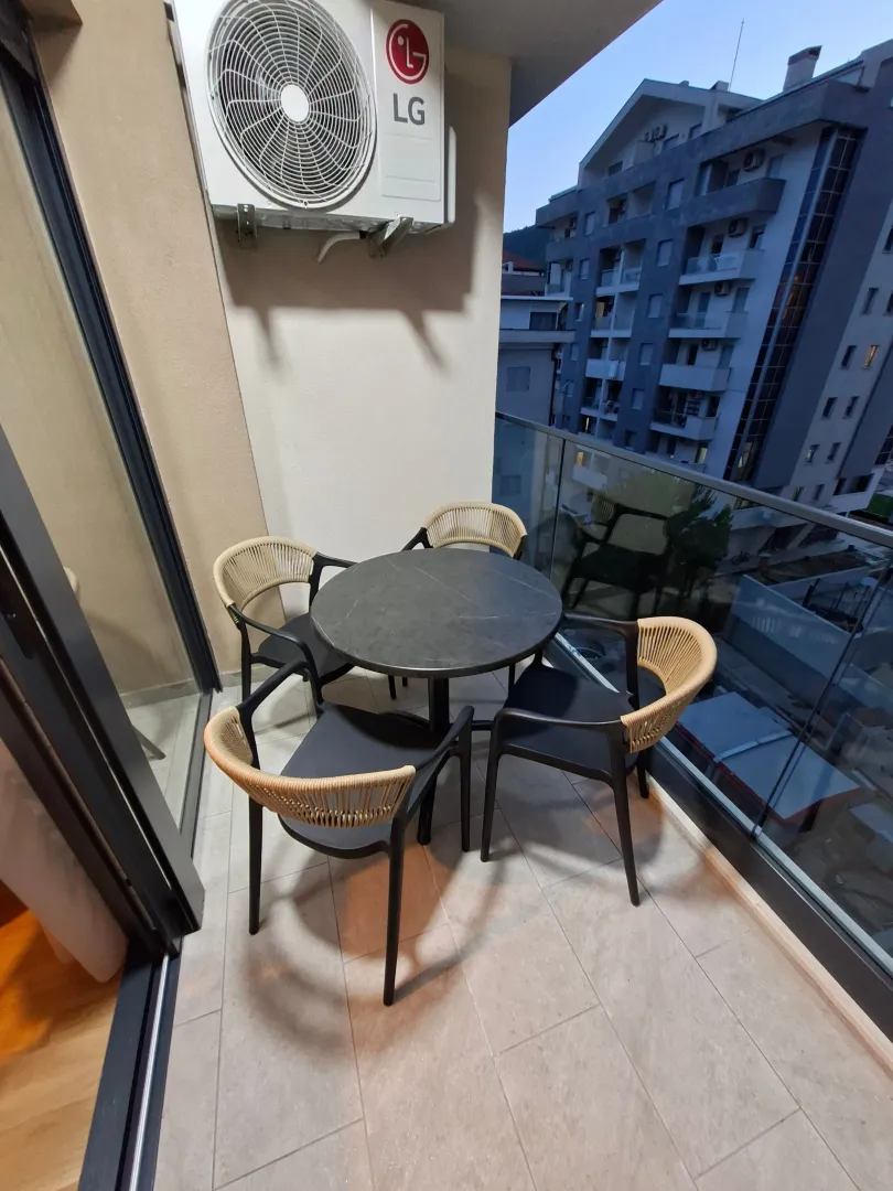 Furnished terrace with a table and chairs and a view of buildings.