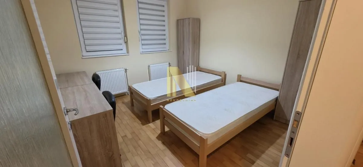 Spavaća soba sa dva kreveta i plakarima.