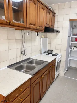 Wooden kitchen with a sink, stove, and tiled walls. - image 3