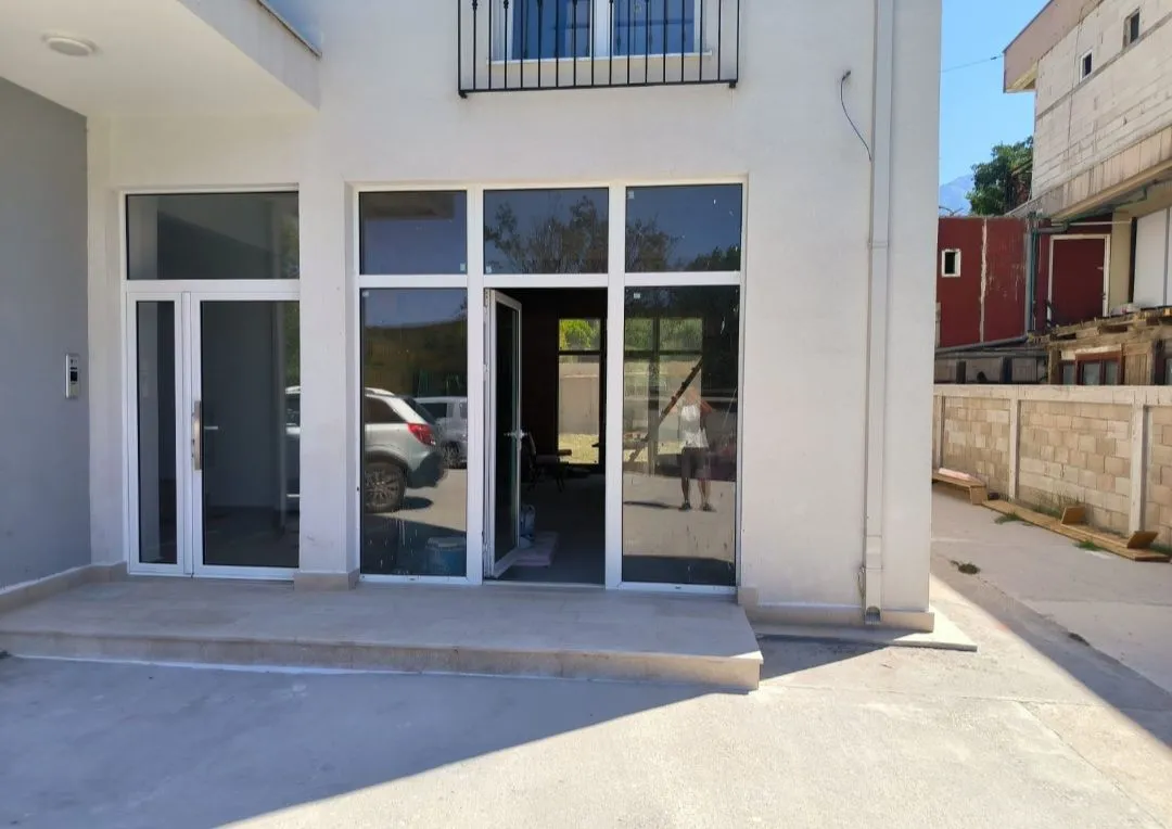 Exterior of the house with large glass entrance doors and windows.