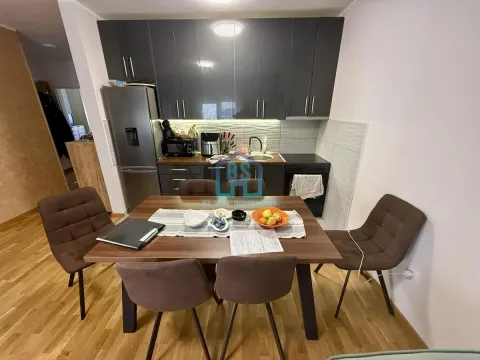 Kuhinja sa tamnim elementima i trpezarijskim stolom sa stolicama. - image 6