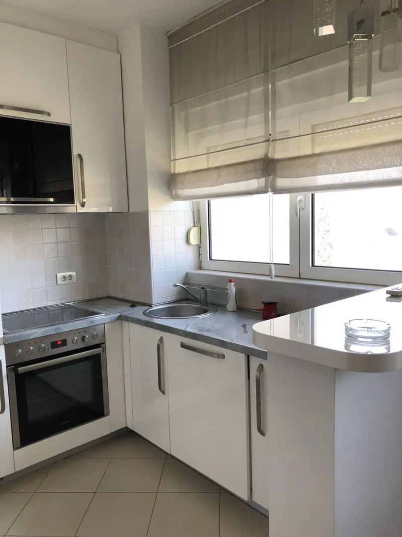 Bright kitchen with white cabinets and built-in appliances.