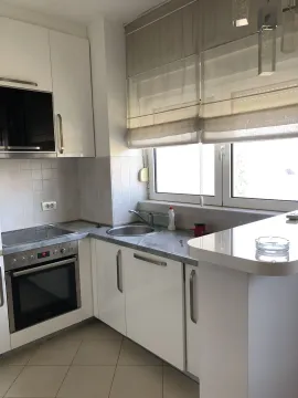 Bright kitchen with white cabinets and built-in appliances. - image 4