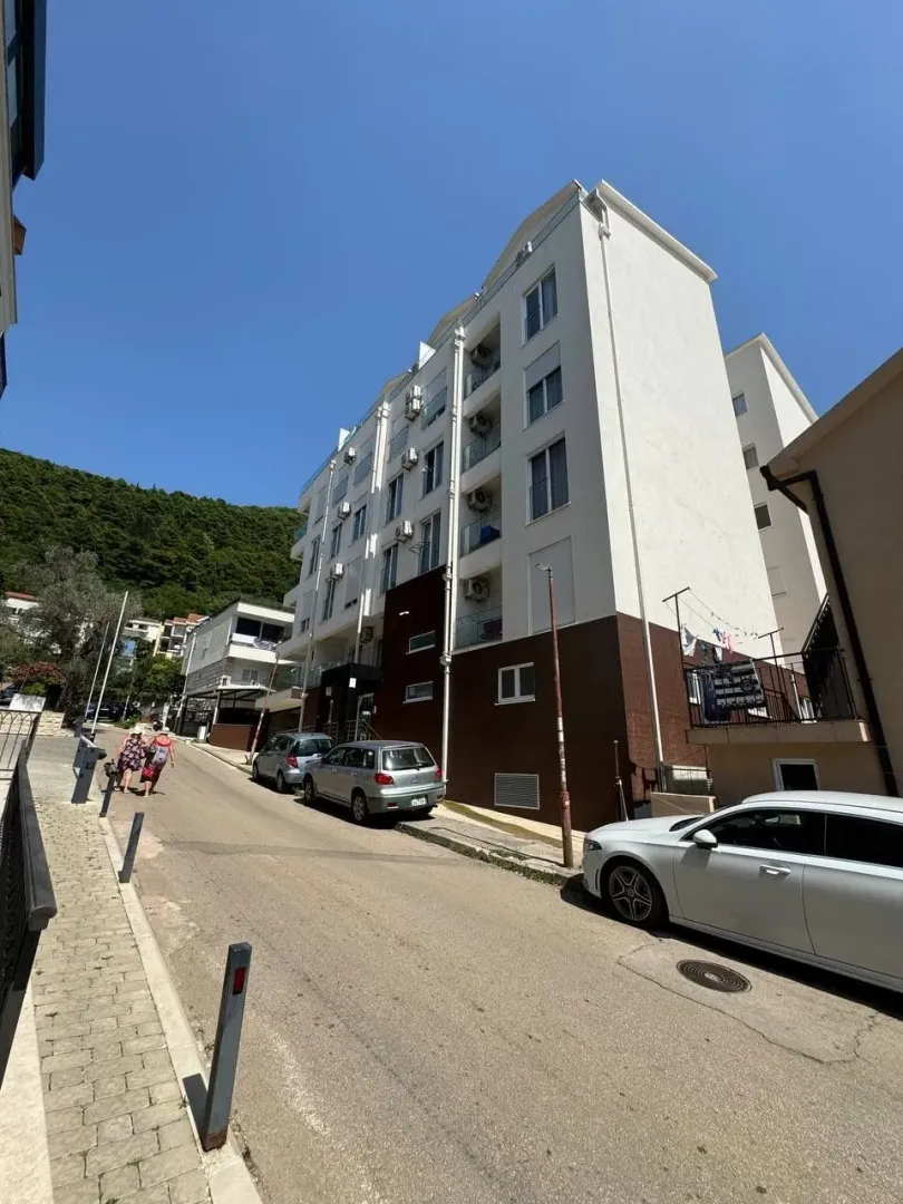 Pogled na spoljašnjost stambene zgrade i ulicu.