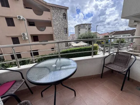 Furnished terrace with a table and chairs and a view of surrounding buildings. - image 7
