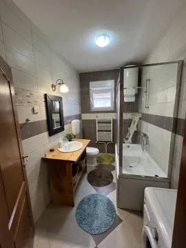 Svijetlo kupatilo sa kadom i drvenim elementima. - image 13
