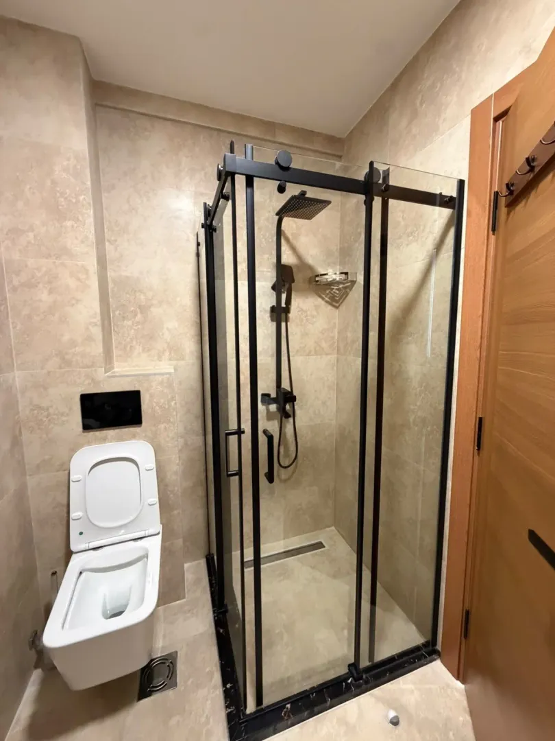 Moderno opremljeno kupatilo sa tuš kabinom i sanitarijama.