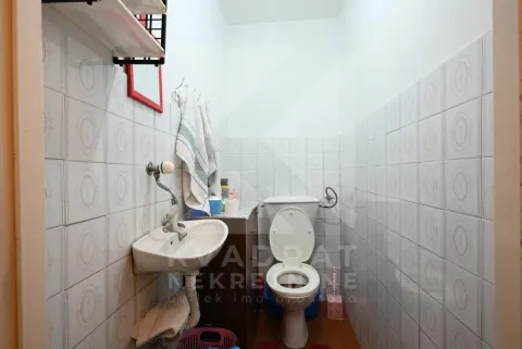 Manje kupatilo obloženo keramičkim pločicama sa umivaonikom i šoljom. - image 15