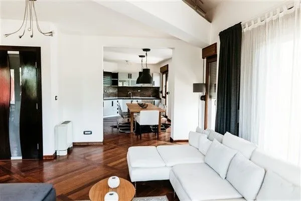 Bright living room with a white corner sofa and a view of the dining area.