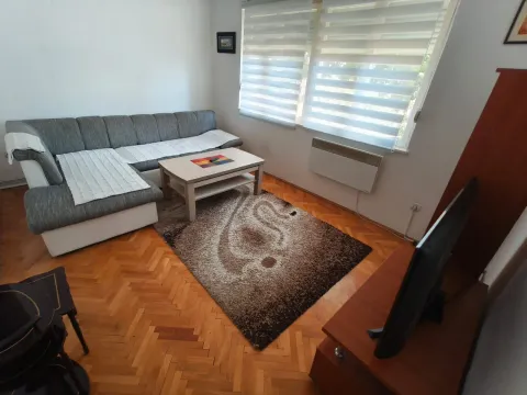 Living room with a sofa, coffee table, and television. - image 8