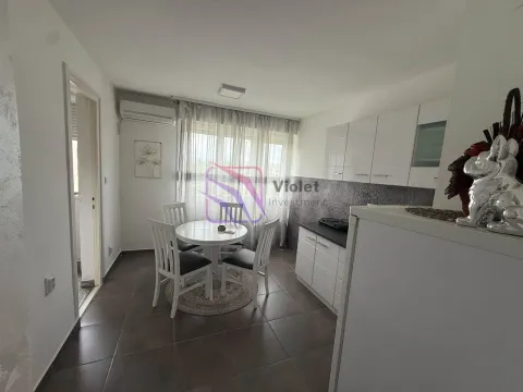 Small kitchen with a dining table and white cabinets. - image 8