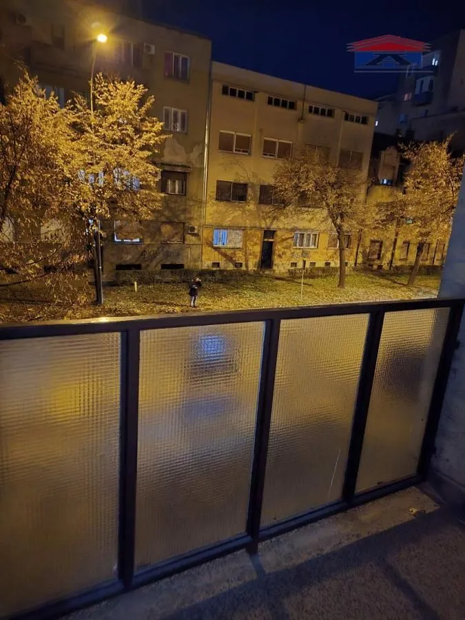 View from the balcony of the illuminated street and building at night.