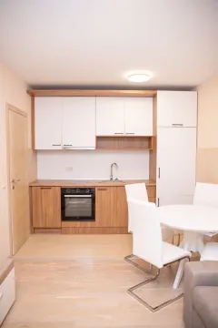 Moderna kuhinja sa bijelim elementima i drvenim detaljima. - image 7