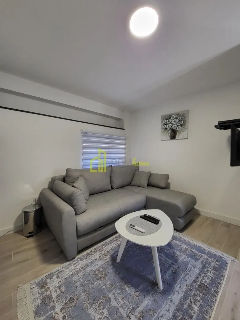 Living room with a corner sofa, coffee table, and TV.