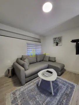Living room with a corner sofa, coffee table, and TV. - image 3
