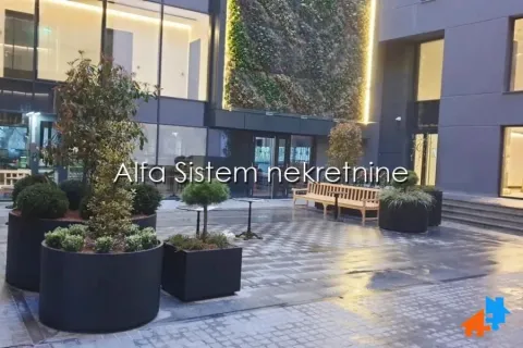 Unutrašnje dvorište zgrade sa popločanim podom i uređenim zelenilom. - image 18